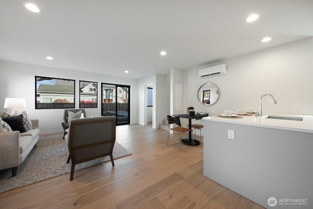 living area with light wood-type flooring, recessed lighting, and a wall mounted AC