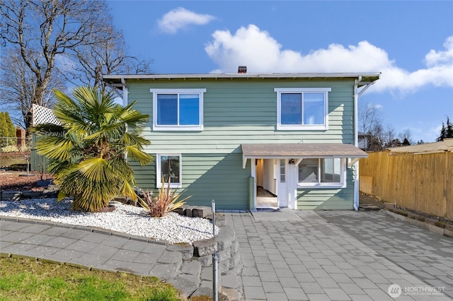 rear view of property featuring fence and a patio