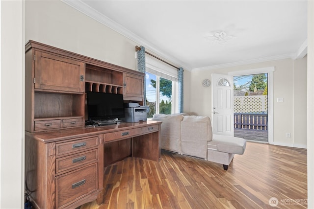 home office featuring crown molding, baseboards, and wood finished floors