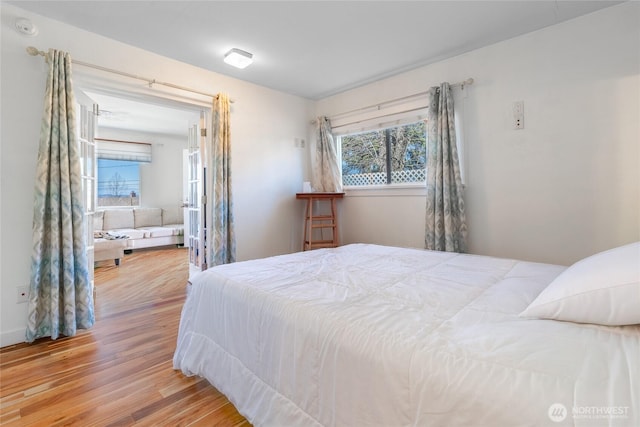 bedroom featuring multiple windows and wood finished floors