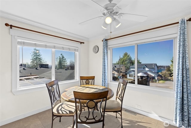 dining room with ceiling fan, ornamental molding, visible vents, and baseboards