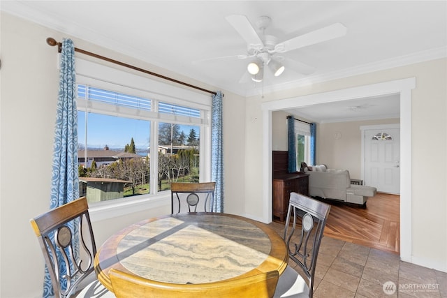 dining room featuring ornamental molding, a ceiling fan, and baseboards