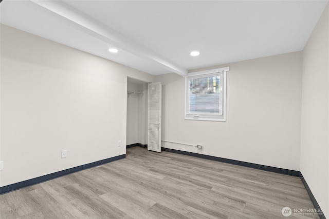 empty room with baseboards, wood finished floors, and recessed lighting