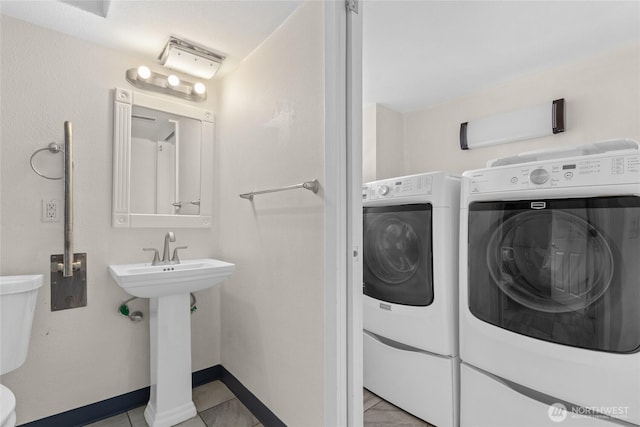 laundry area with a sink, laundry area, baseboards, and washer and dryer