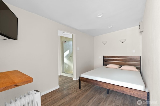 bedroom with radiator heating unit, wood finished floors, and baseboards