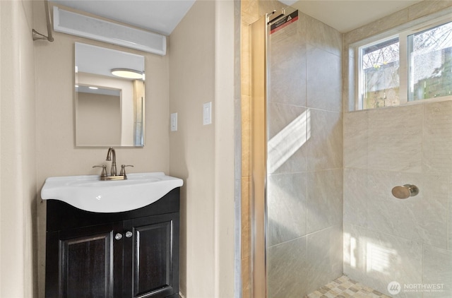 bathroom featuring tiled shower and vanity