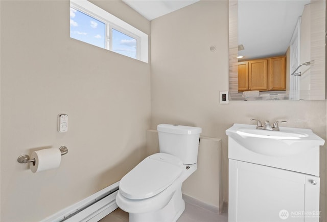 half bath featuring a baseboard heating unit, vanity, and toilet