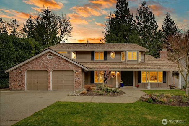 traditional home featuring brick siding, board and batten siding, a lawn, a garage, and driveway