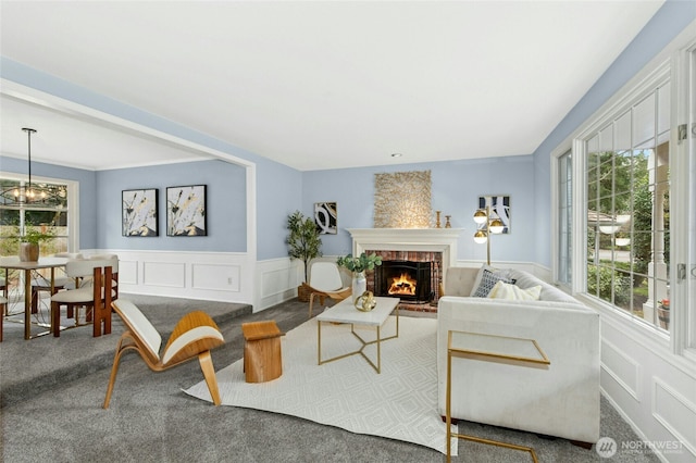 carpeted living room featuring a decorative wall, a fireplace, and a wealth of natural light