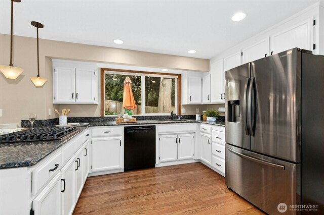 kitchen with light wood finished floors, gas stovetop, a sink, black dishwasher, and stainless steel refrigerator with ice dispenser