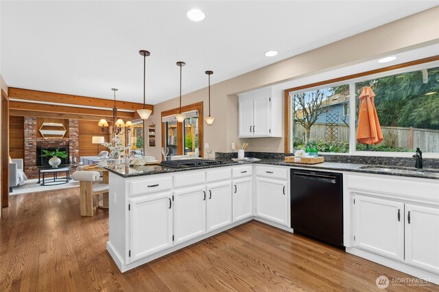 kitchen featuring a chandelier, dishwasher, a peninsula, gas stovetop, and a sink