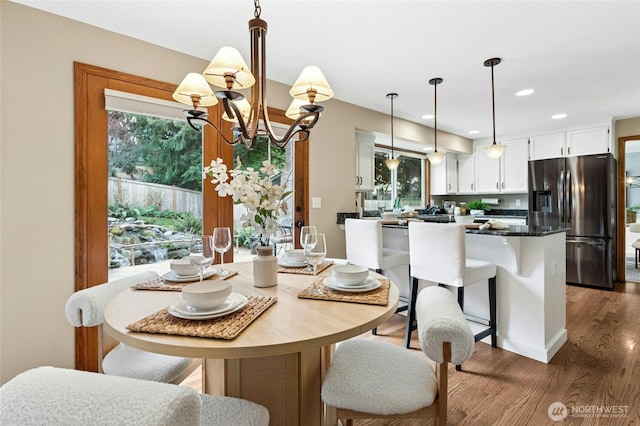 dining room with a chandelier, recessed lighting, and wood finished floors