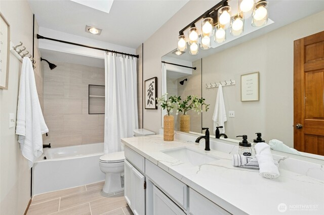 full bath featuring toilet, a skylight, vanity, and shower / tub combo