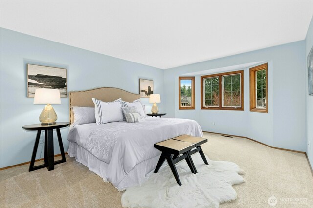 carpeted bedroom with visible vents and baseboards