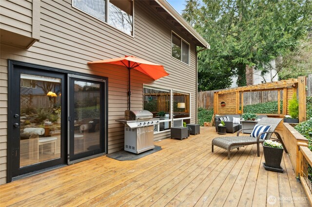 wooden terrace featuring grilling area, an outdoor hangout area, and fence