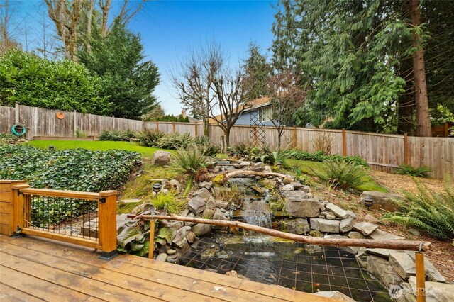 wooden deck with a fenced backyard