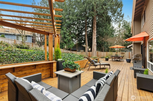 wooden terrace with a pergola, outdoor lounge area, outdoor dining area, and fence