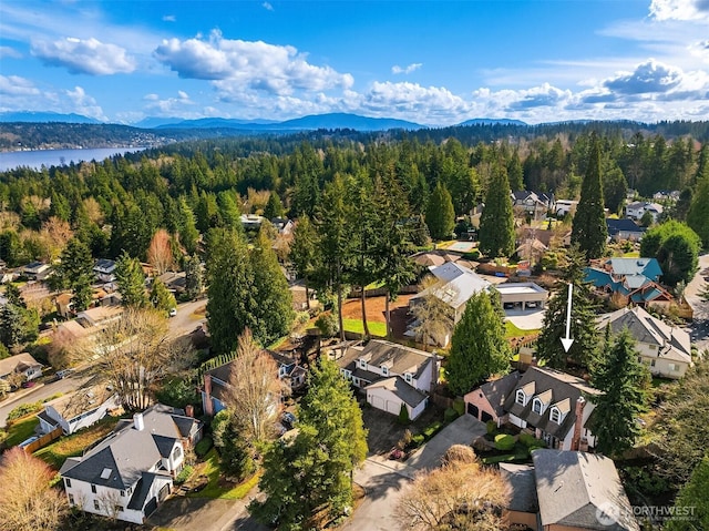 aerial view with a forest view, a water and mountain view, and a residential view