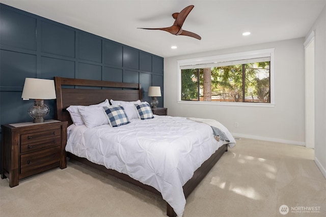 bedroom with light carpet, baseboards, a decorative wall, and a ceiling fan