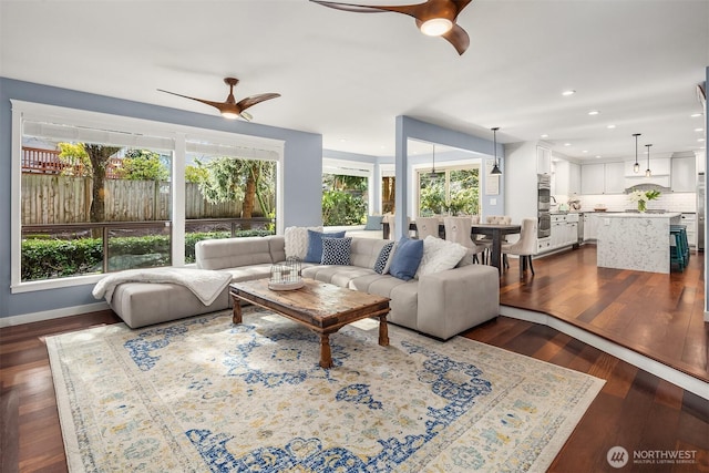 living room with dark wood-style flooring, a ceiling fan, and recessed lighting