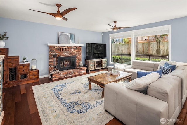 living room with a fireplace, baseboards, a ceiling fan, and wood finished floors