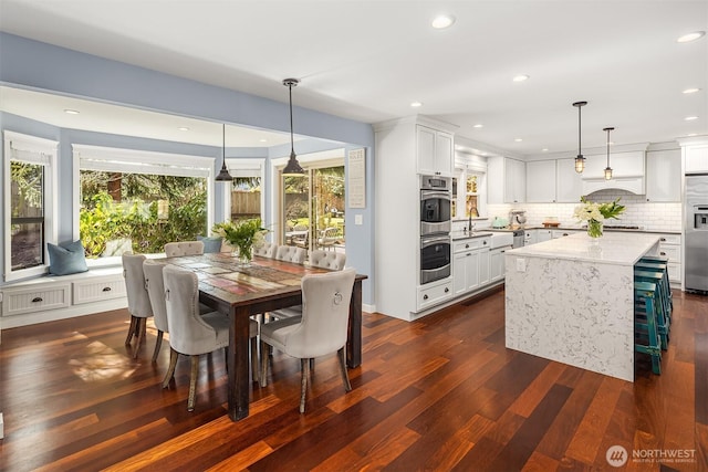 dining area with dark wood-type flooring and recessed lighting