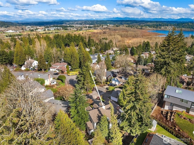 aerial view with a water view and a forest view