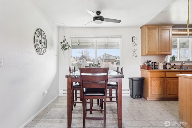 dining area with plenty of natural light, a ceiling fan, and baseboards