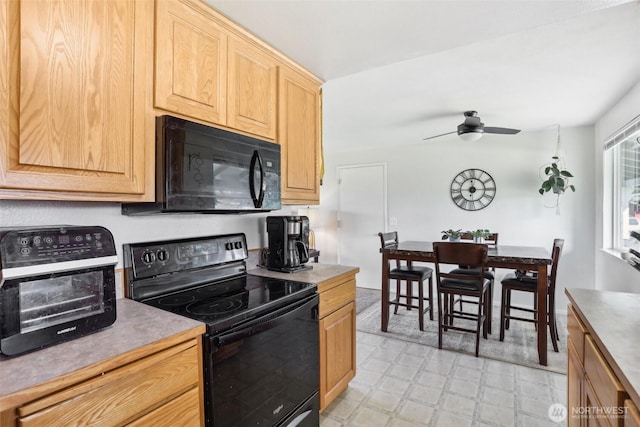 kitchen with light floors, a toaster, a ceiling fan, light brown cabinetry, and black appliances