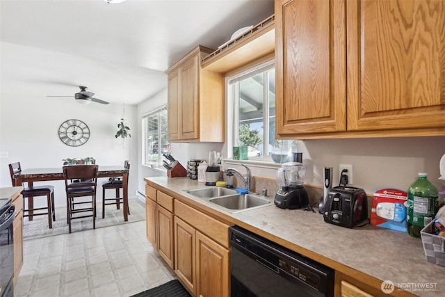 kitchen featuring black dishwasher, a ceiling fan, light countertops, light floors, and a sink