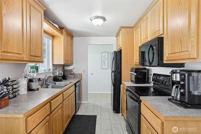 kitchen with baseboards, a sink, black appliances, and light brown cabinetry