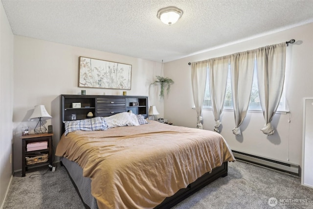 carpeted bedroom with a textured ceiling, baseboard heating, and baseboards