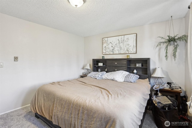 carpeted bedroom featuring a textured ceiling and baseboards