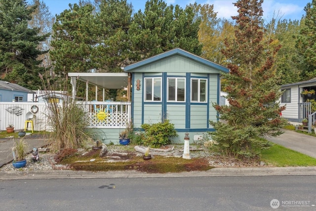 manufactured / mobile home with concrete driveway and a porch