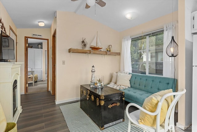 sitting room with baseboards, visible vents, dark wood finished floors, ceiling fan, and vaulted ceiling