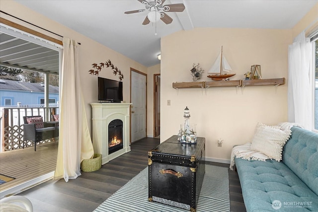 living room with dark wood-style floors, a glass covered fireplace, plenty of natural light, and lofted ceiling