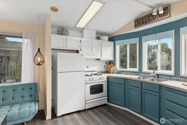 kitchen featuring vaulted ceiling, a wealth of natural light, white appliances, and a sink