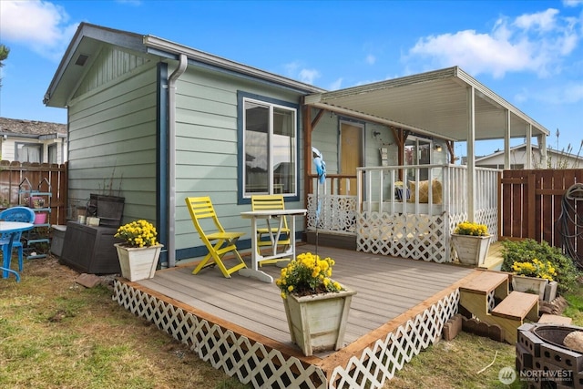 back of house featuring fence and a wooden deck