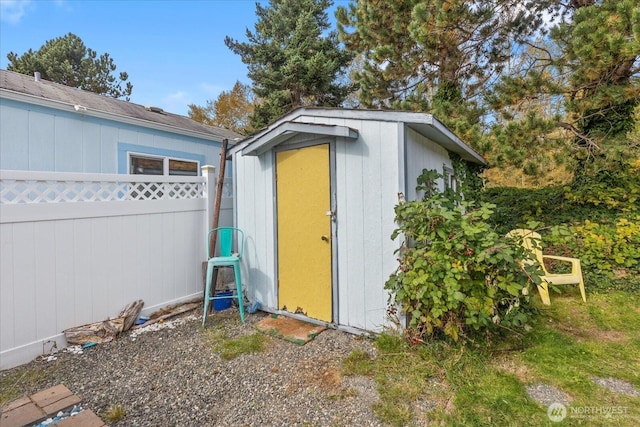 view of shed featuring fence