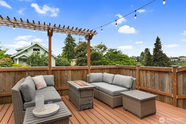 wooden terrace with an outdoor living space with a fire pit