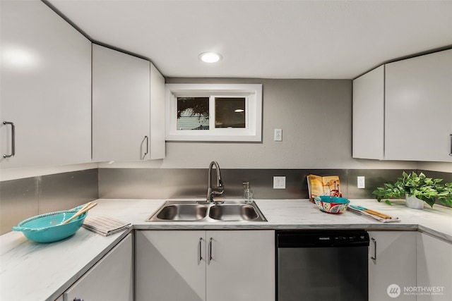 kitchen featuring dishwasher, white cabinetry, light countertops, and a sink