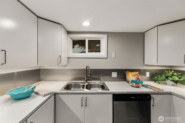 kitchen featuring dishwasher, white cabinetry, light countertops, and a sink