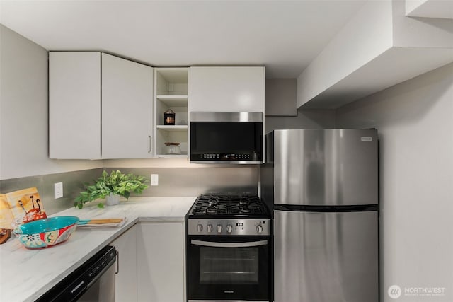 kitchen with open shelves, white cabinets, modern cabinets, and appliances with stainless steel finishes