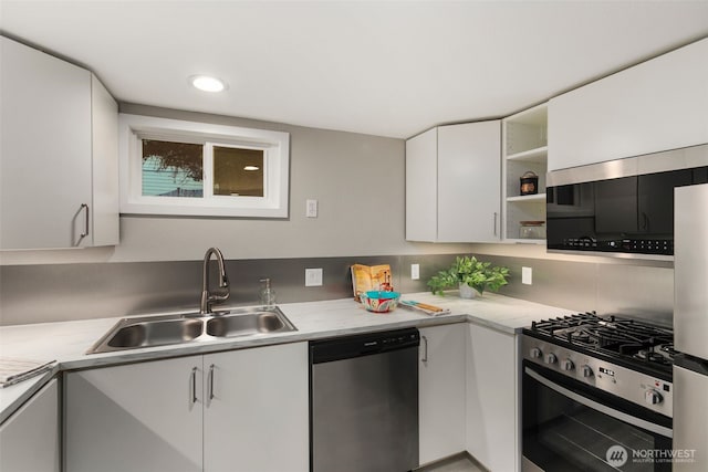 kitchen featuring a sink, stainless steel appliances, white cabinetry, and light countertops