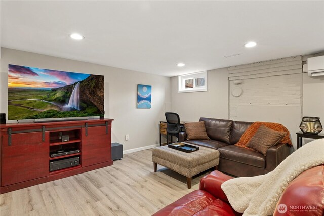 living room featuring recessed lighting, baseboards, an AC wall unit, and light wood-style flooring