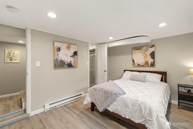 bedroom featuring recessed lighting, a baseboard radiator, and wood finished floors