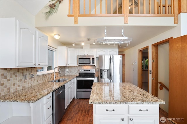 kitchen with backsplash, light stone counters, stainless steel appliances, and a sink