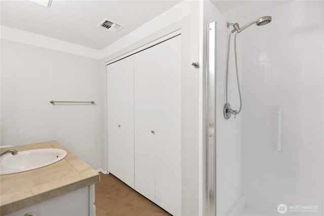 bathroom featuring a shower stall, visible vents, and vanity