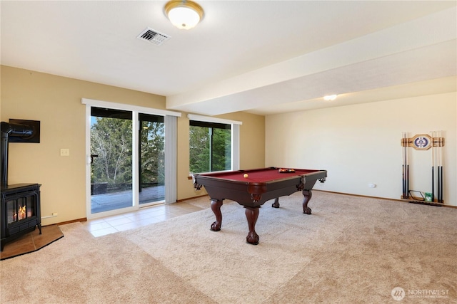 game room featuring pool table, visible vents, a wood stove, carpet flooring, and baseboards