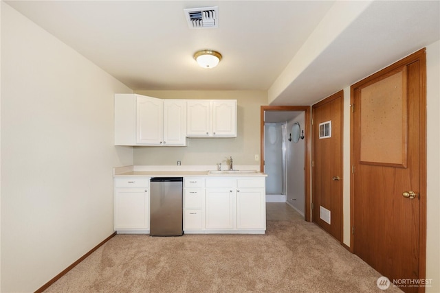 kitchen with visible vents, a sink, light carpet, and stainless steel dishwasher